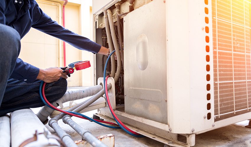 An HVAC technician diagnoses a commercial HVAC unit leak